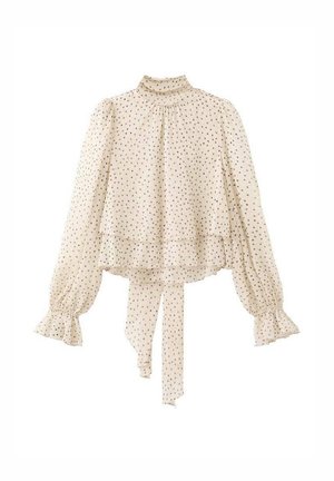Svetlobéžová blúzka s dlhými rukávmi a malými čiernymi bodkami, s vysokým golierom, volánikovými manžetami, vrstveným okrajom a mašľou vzadu.