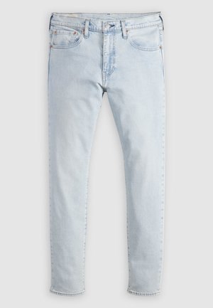 Jean en denim bleu clair avec une coupe slim, comprenant cinq poches, des rivets en cuivre et une coupe droite pour les jambes. Coutures simples sur les ourlets.
