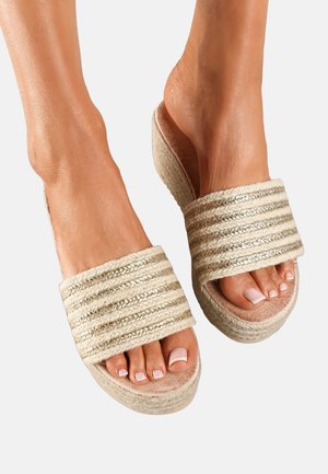 Sandales à bout ouvert avec une tige tissée dorée et beige rayée, semelle intérieure profilée et une semelle épaisse et texturée pour un confort accru.
