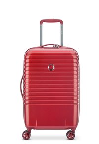 Valigia rigida rossa con design a coste verticali, manico estensibile, quattro ruote girevoli e un sistema di chiusura sulla parte anteriore.