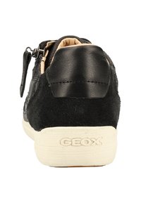 Baskets noires alliant cuir lisse et daim, avec une semelle extérieure texturée et un logo Geox bien visible au talon.