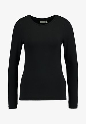 Mustaste pikkade käistega särk, mis on valmistatud pehmest puuvilla ja sünteetika segust. Omab ümmargust kaelust ja kehakujulist lõiget koos siledat tekstuuri. Ilma mustrite ja aktsentideta.