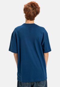 Mörkblå bomulls-t-shirt med korta ärmar, avslappnad passform och rundad halsringning, med en sömlös bakdesign.