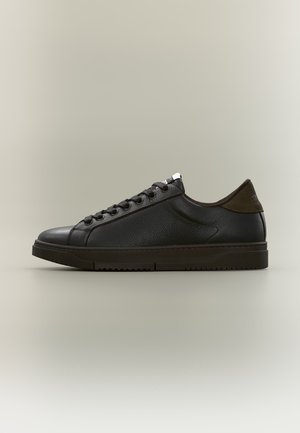 Czarny, niskoprofilowy skórzany sneaker z wiązaniem i teksturowaną podeszwą, pokazany z profilu na neutralnym tle.
