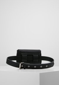 Borsa nera a cintura con una tasca rettangolare. Realizzata in materiale simile alla pelle, presenta dettagli metallici e una tracolla regolabile con più fori.