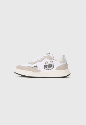 White and beige sneaker with black sole, silver accents, white laces, and a cat face design made of black studs on the side.