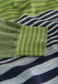 Knitted sweater featuring green and gray fabric with varying striped patterns in dark blue, brown, and light blue. Soft texture with ribbed cuffs.