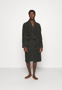 Ruteret badekåbe i mørkegrå og sort, lavet af blødt stof, har lange æermer, et bælte og en længde til knæene.