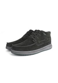 Zapatos de ante negro con un diseño de parte baja, que presentan una suela de goma resistente, cordones redondos y sutiles acentos de costura.