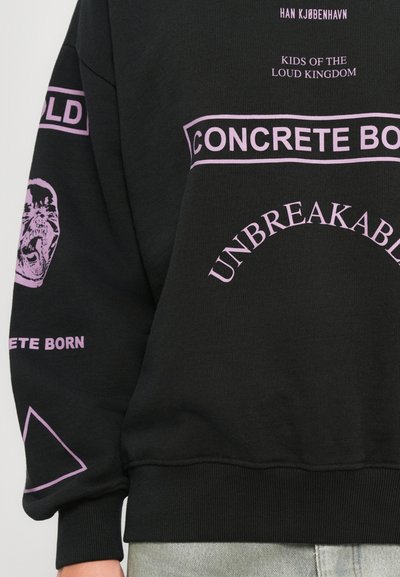 Hanorac negru cu text violet, inclusiv "CONCRETE BORN", "UNBREAKABLE", "KIDS OF THE LOUD KINGDOM" și o față de animal răcnind pe mânecă.