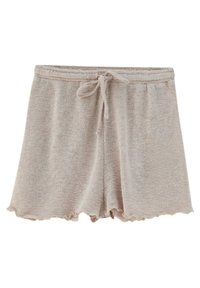 Beige neulehousut, joissa on teksturoitu pinta, joustava vyötärönauha ja naru. Lisäyksinä on aaltoileva helma.