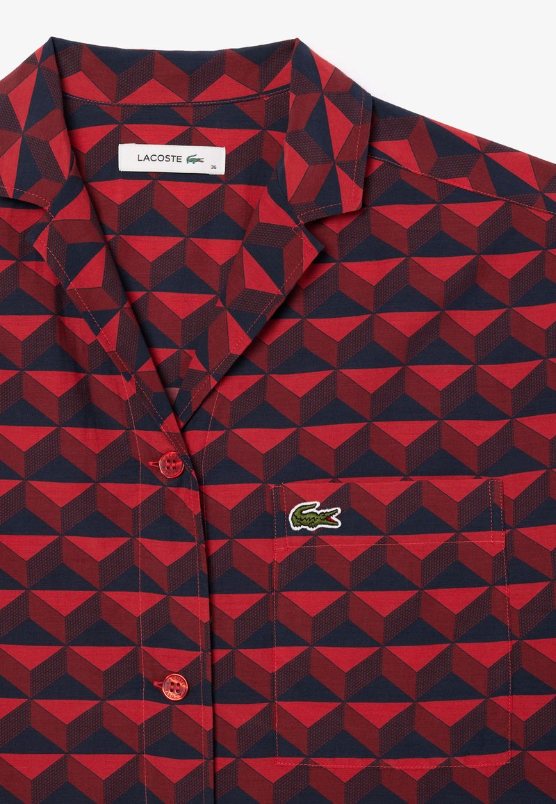 Rot und marineblau gemustertes Hemd mit Kragen, Knopfverschluss und einer linken Brusttasche mit Lacoste-Logo.