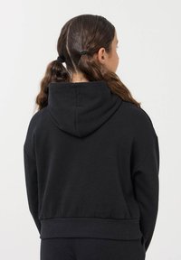 Felpa nera cropped con cappuccio e orlo a coste, con spalle scese e una texture morbida, vista da dietro.