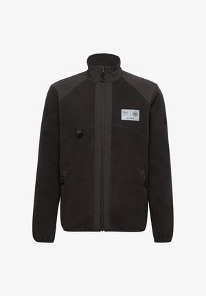 Schwarze Fleecejacke mit hohem Kragen, Frontreißverschluss, zwei Seitentaschen und einem Brustpatch. Sie verfügt über kontrastierende Schulterpaneele und eine glatte Textur.