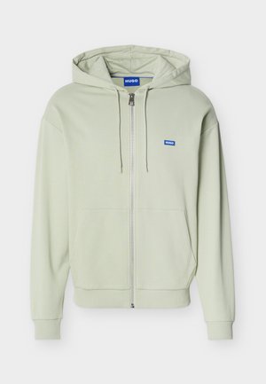 Heleheleroheline lukuga dressipluus esitaskute, nööriga kapuutsi, soonikutega varrukate ja äärega ning väikese sinise "HUGO" logoga rinnal.