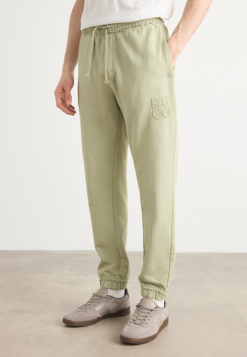Hellgrüne Sweatpants mit elastischem Bund und Kordelzug. Merkmale sind das gestickte "HUGO"-Logo, elastische Bündchen an den Knöcheln und eine lässige Passform.