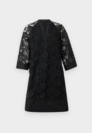 Μαύρο φόρεμα μήκους μέχρι το γόνατο με επικάλυψη από λουλουδάτη δαντέλα, διάφανα μανίκια δαντέλας τριών τετάρτων, V-λαιμόκοψη και μαύρες στερεές μανσέτες και κάτω μέρος.