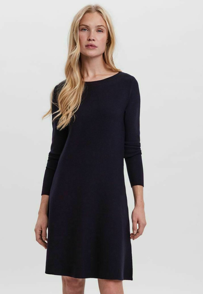 Robe en tricot bleu marine avec un col rond, des manches longues et une forme évasée, présentant une texture lisse et un design minimaliste.