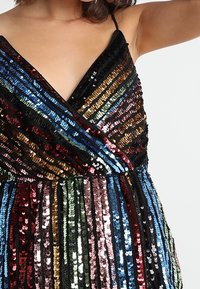 Ärmelloses V-Ausschnitt-Kleid mit mehrfarbigen vertikalen und diagonalen Paillettenstreifen in Schwarz, Blau, Gold, Pink, Grün und Rot.