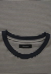 Mėlynos ir smėlio spalvos dryžuota medvilninė marškinėliai su apvalia iškirpte. Savybė – smulkios horizontalios juostelės ir etiketė su užrašu „Matinique“.