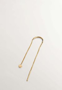 Joya de tono dorado que presenta un aro curvado y dos cadenas. Una cadena termina en un colgante redondo, mientras que la otra termina en una barra cilíndrica corta.