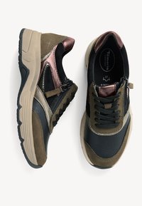 Baskets marron et noires avec une tige en cuir texturé et en suède. Elles présentent une semelle beige épaisse, des accents métalliques et un laçage à l'avant.