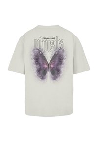 Light grey t-shirt featuring a large purple butterfly graphic on the back, with the text "migonales" above in black gothic font.