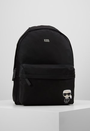 Sort rygsæk med lynlåslomme foran, Karl Lagerfeld-logo øverst og lille Karl Lagerfeld-tegneseriefigur på den nederste højre lomme.