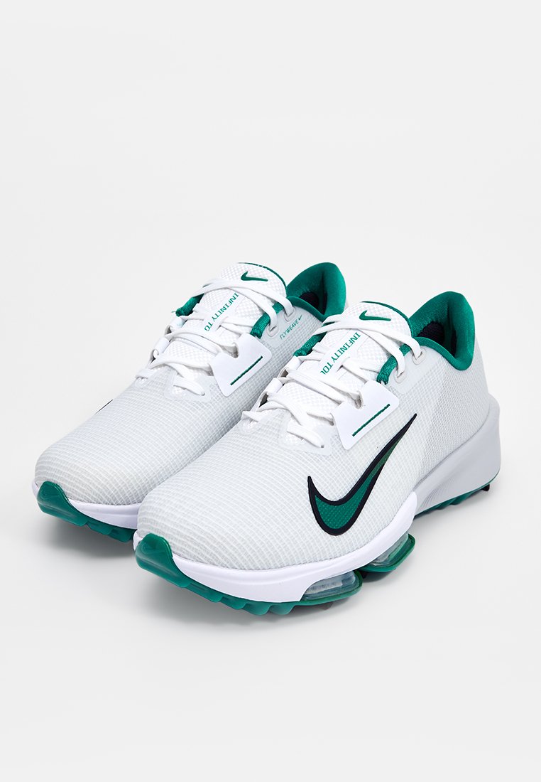 Baskets de sport blanches avec une tige en mesh texturé, des accents verts et un logo Nike noir. Comprend un col rembourré et une semelle coussinée.