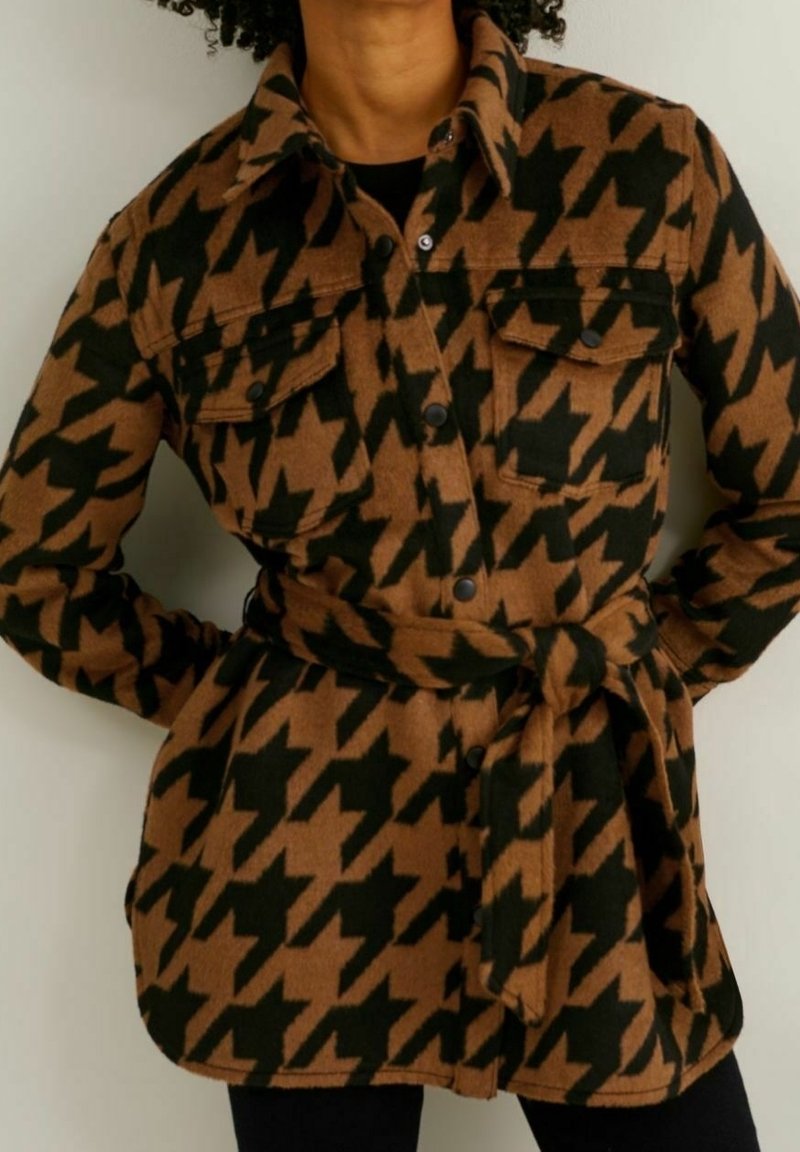 Giacca a motivo houndstooth marrone e nero con cintura a cravatta, dotata di colletto, tasche frontali e chiusura con bottoni. Tessuto morbido e testurizzato.