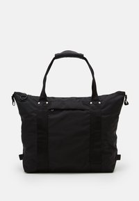 Sac fourre-tout noir en nylon avec deux poignées supérieures, fermeture éclair, poche frontale et coutures renforcées. Texture lisse et design spacieux.