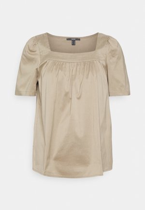 Beige kurzärmlige Bluse mit quadratischem Ausschnitt, plissiertem Vorderteil und dezentem Nahtdetail an den Schulterpaneelen.