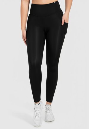 Leggings neri con vita alta e tasca laterale. Realizzati in tessuto liscio e elasticizzato, presentano una vestibilità aderente e un design elegante.