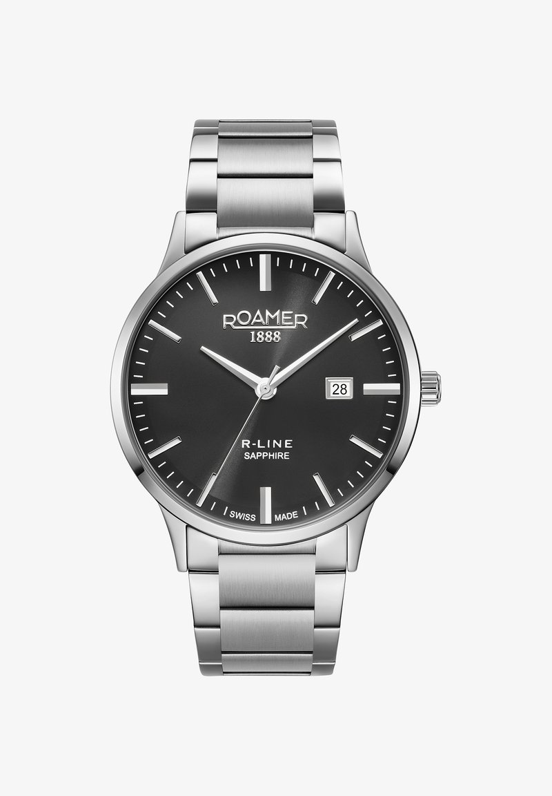 Nerūdijančio plieno laikrodis su juodu ciferblatu, sidabriniais valandų žymekliais, datos rodmeniu ir šlifuoto metalo apyranke. Prekės ženklas 12 valandos pozicijoje.