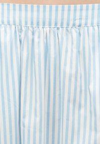 Ελαφρύ ύφασμα με κατακόρυφες ρίγες σε ανοιχτό μπλε και λευκό, με πουγκωτή ραφή κοντά στο πάνω άκρο.