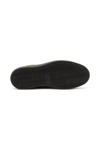 Suela de goma negra con un patrón de espiga, que presenta una superficie texturizada y un detalle de logo, parte de un diseño de zapato.