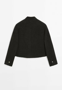 Short, dark woolen jacket with a collar, cropped design, and long sleeves. Features gold-colored button accents on sleeves.