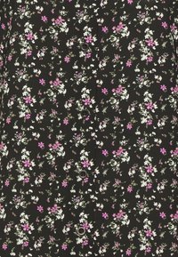Tessuto nero con un motivo floreale che presenta fiori bianchi e rosa, cinque bottoni che si estendono al centro e una superficie liscia.