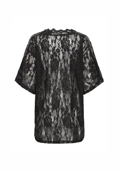 Haut en dentelle noire à manches courtes, avec un motif floral et une coupe décontractée. Le tissu est semi-transparent avec un col festonné.