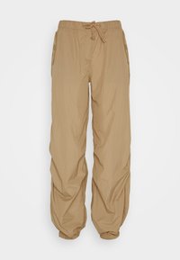 Beige, lichtgewicht broek met een elastische tailleband en een trekkoord. Voorzien van zijzakken en ingesnoerde enkels voor een ontspannen pasvorm.