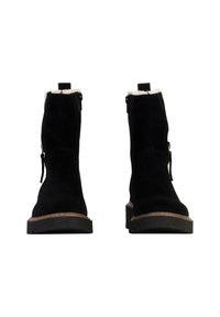Zwarte suède enkellaarsjes met een gestructureerde afwerking, ritsdetails en een dikke rubberen zool. Zachte voering die bovenuit steekt.