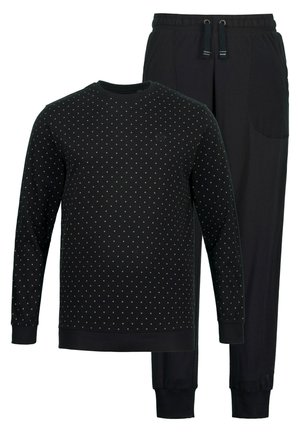 Set di abbigliamento casual nero composto da un top a maniche lunghe con motivo a pois bianchi e pantaloni neri con polsini elasticizzati e tasche laterali.