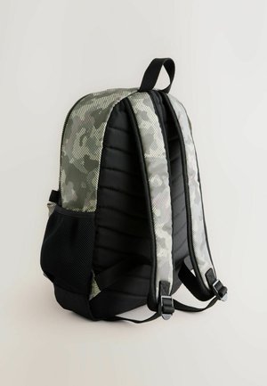 Maskovací batoh s polstrovanými boky, černými síťovinovými kapsami a nastavitelnými popruhy. Obsahuje horní uchopení a akcenty z texturované tkaniny.