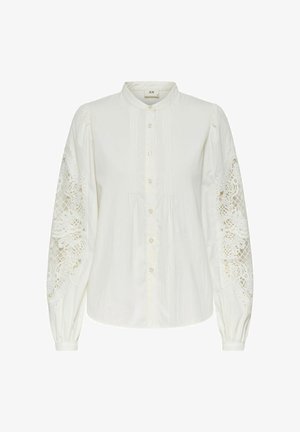 Valge pikkade varrukatega pluus, millel on volangvarrukad ja keerukad pitsidetailid ning nööbid ees. Sile tekstuur ja klassikaline krae disain.