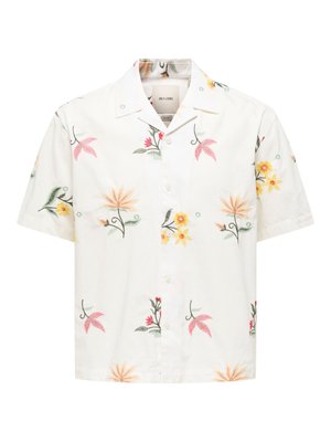 Chemise blanche à manches courtes, boutonnée, avec un col large et des motifs floraux multicolores en jaune, rose et vert.