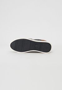 Black sneaker sole with textured rubber for grip, featuring a white midsole and an orange accent. Flat shape with no prominent design elements.