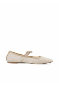 Bailarinas, de tejido beige claro, adornadas con pequeños remaches metálicos, puntera redondeada y una suave correa con un detalle de lazo en el tobillo.
