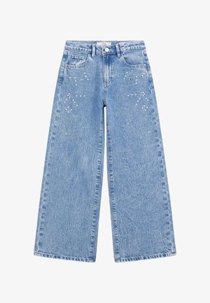 Jeans a gamba larga di un blu chiaro con una texture sbiadita, caratterizzati da decorazioni, tra cui borchie di argento e strass nella parte anteriore.