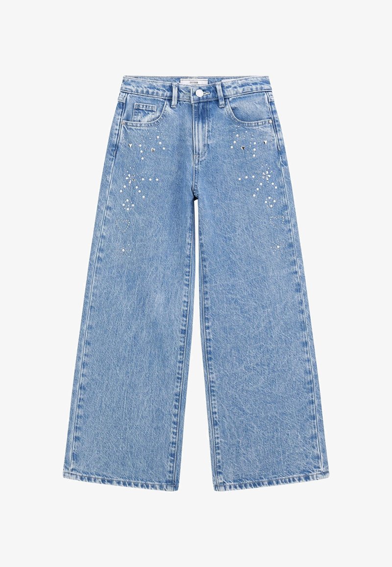 Svijetloplave traperice širokih nogavica s izblijedjelom teksturom, koje sadrže dekorativne ukrase, uključujući srebrne zakovice i rhinestone na prednjem dijelu.