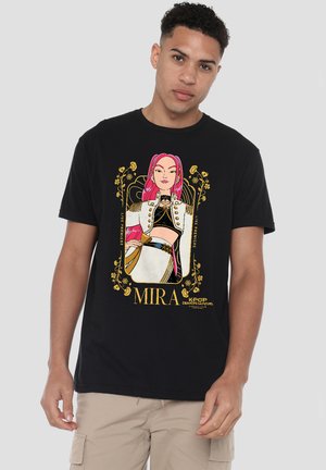 Young man wearing black T-shirt with colorful anime-style female character with pink hair and gold floral frame, text "MIRA" and "KPOP DEMON HUNTERS."